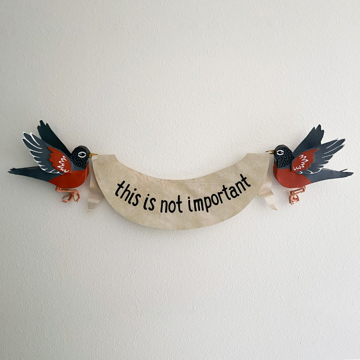 The Robins Are Judging You, Paper Mache Robins Holding This Is Not Important Banner